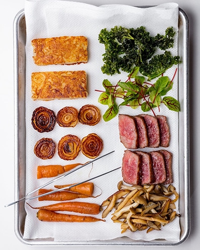 a platter with different food types including meat, vegetables and confectionaries