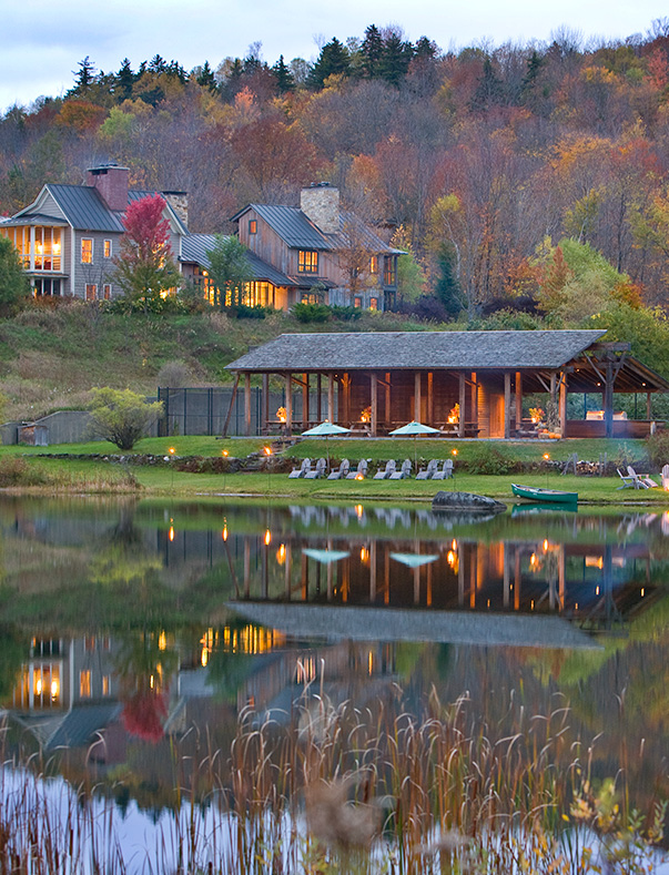 Wooden cottages in front of a lake with woods in the background